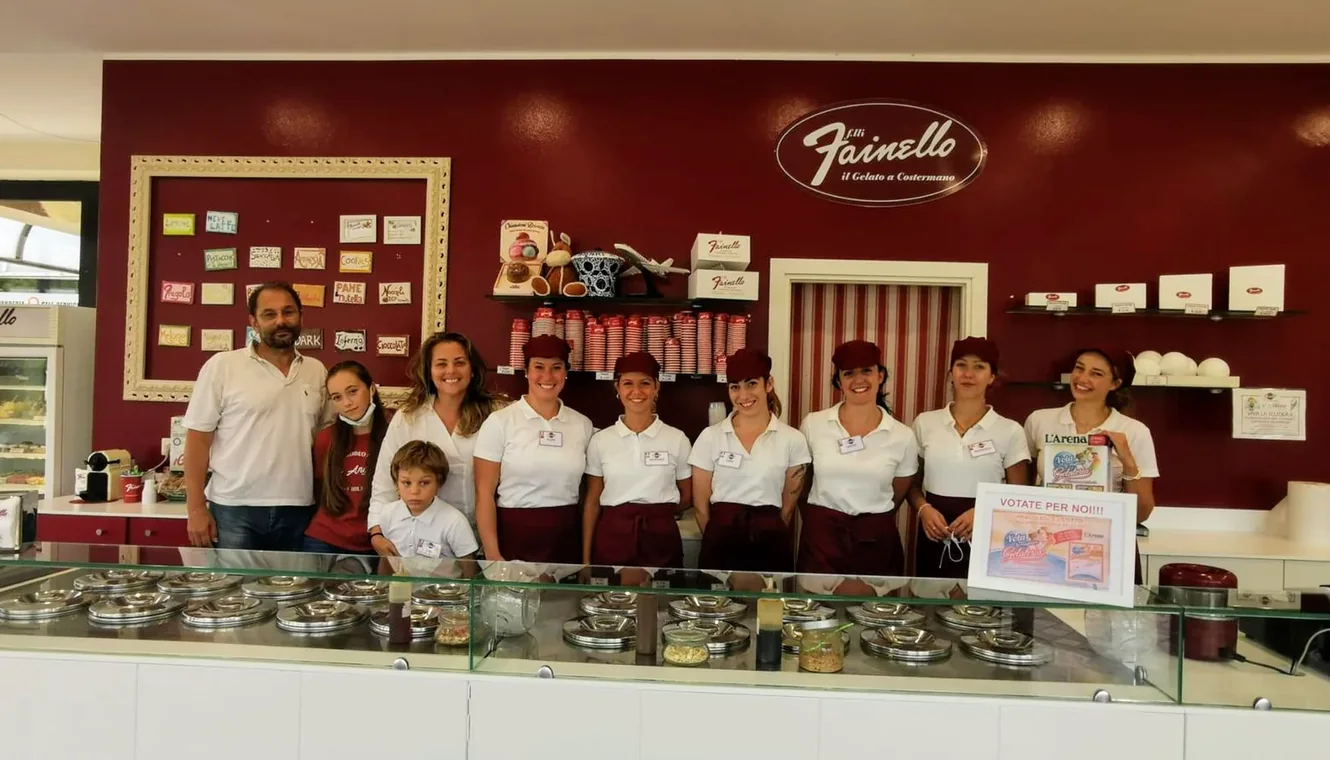 Il team Fainello schierato dietro il banco del gelato, nel locale di Costermano