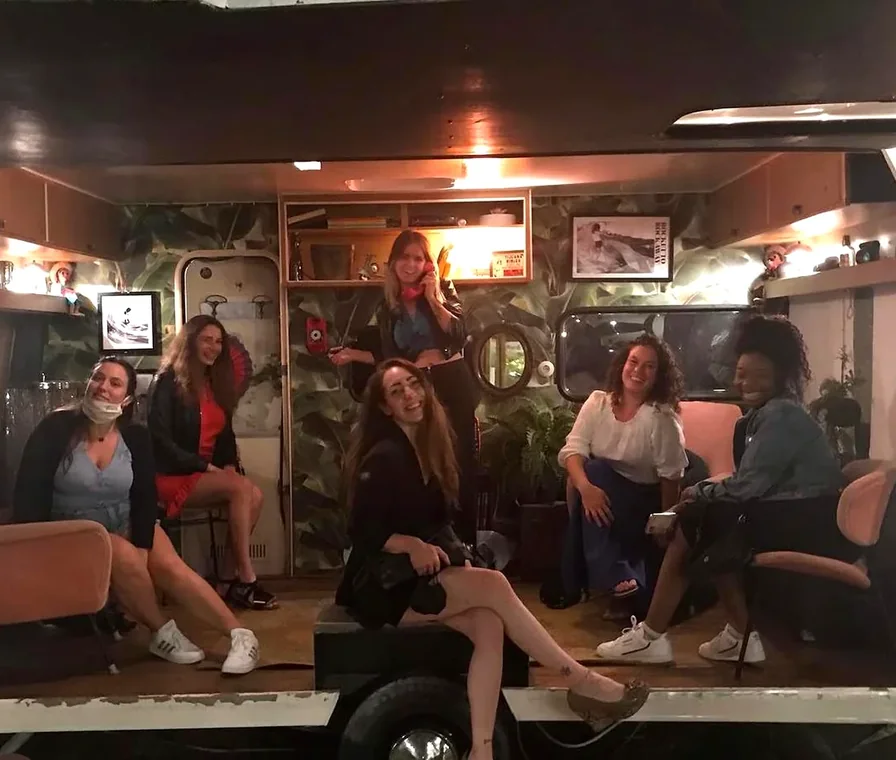 Ragazze del team sedute e sorridenti durante una serata fuori dal lavoro